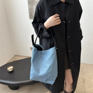 Sac seau en denim bleu clair avec bandoulières en cuir noir pour le style décontracté chic