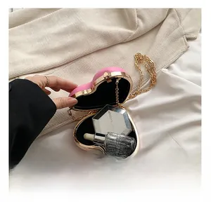 Detail showing internal capacity of heart-shaped pink evening bag with gold chain strap
