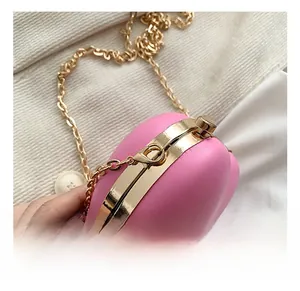 Detail of gold metal hook and ball clasp on a pink heart-shaped mini crossbody bag