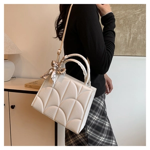 Détail du sac à bandoulière matelassé blanc avec foulard en soie sur l'anse