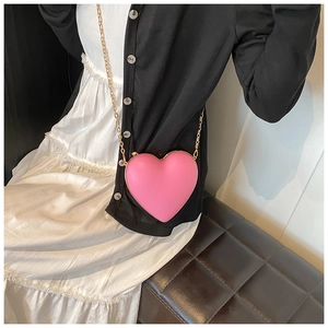 Detail view of pink heart-shaped crossbody bag with gold chain and metal frame
