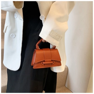 Vue détaillée de la texture cuir grainé caramel et de la poignée structurée du sac à main