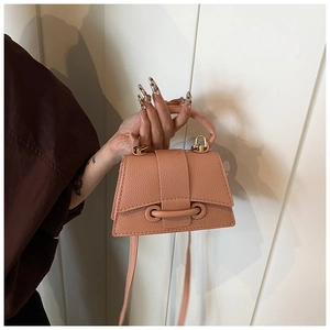 Détail du sac à main orange-rose avec motif litchi, fermoir doré et poignée supérieure