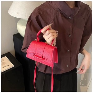 Détail du sac à main en cuir rose avec poignée ronde et fermeture à rabat élégante