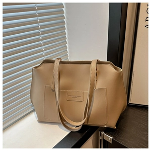 Dettaglio della borsa tote in pelle kaki con tasca frontale e luce d'ombra morbida