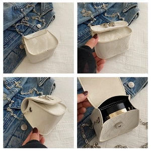 Detalle del bolso de cadena blanco perlado con textura de mármol y herrajes plateados finos