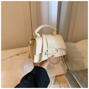 Détail du sac à main en cuir grainé avec rabat asymétrique et boucles dorées
