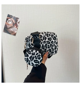Détail du sac bandoulière léopard avec un petit porte-monnaie rond et finitions dorées