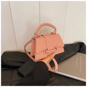 Détails de la texture rose motif litchi et boucle à anneau sur ce petit sac carré chic