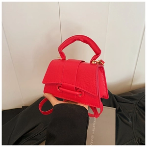 Détail du sac à main rouge en cuir grainé avec poignée épaisse et boucle métallique chic