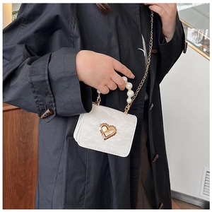 Detail showing white marble texture mini bag with pearl handle and gold heart lock