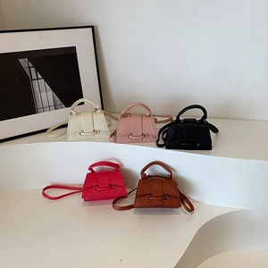 Sacs bandoulière minimalistes texture litchi en cinq couleurs sur un présentoir blanc
