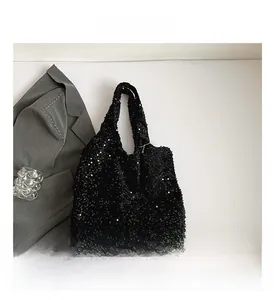 Close-up of black sequined tote bag surface with dense glittery texture and detail