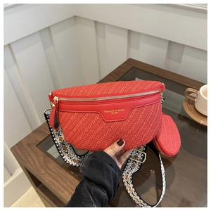 Dettaglio della borsa a tracolla rossa intrecciata con tracolla boho e logo dorato