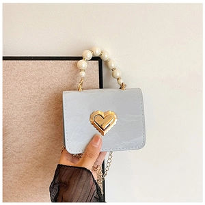 Detail of light blue marble leather bag with golden heart lock and pearl handle