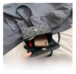 Detail view showing interior capacity for phone and cosmetics in bow-knot mini bag