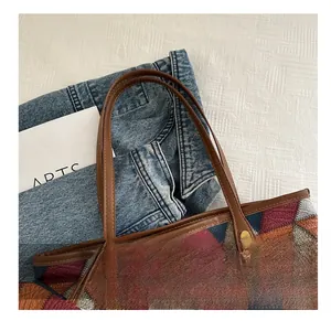 Dettaglio della pelle con trama litchi patchwork e manici marroni rinforzati della borsa
