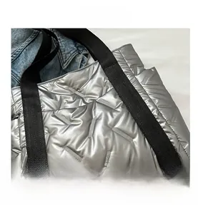 Detailed macro view of silver quilted nylon tote bag with black durable straps