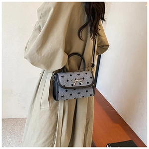 Fashionable gray polka dot small square bag worn over a beige trench coat