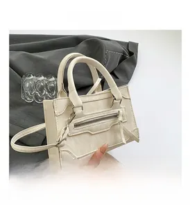 Detail view of the cream white crossbody bag with marble texture and silver zipper pocket