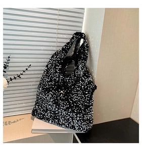 Detail shot of black sequin tote bag with shimmering metallic texture for daily commute