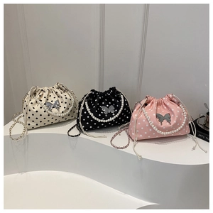 Detailed view of polka dot bucket bags with butterfly charms and pearl handles