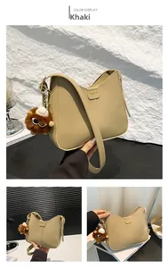 Dettaglio borsa a mezzaluna kaki con logo FASHION e ciondolo a forma di mostro