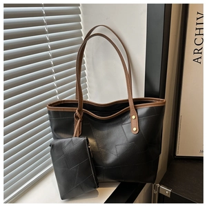 Dettaglio borsa tote nera patchwork con bordo marrone e piccolo astuccio coordinato