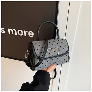 Close-up of heart print mini bag with silver bow buckle and synthetic leather strap