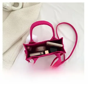 Draufsicht auf rosa Filz-Tasche zeigt großen Innenraum mit Handy und Kosmetik