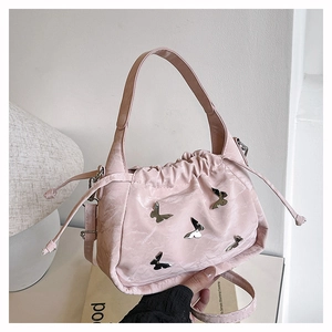 Close-up of pink ruched bucket bag with silver butterfly charms and leather texture