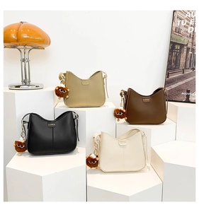 Detailed close-up of fashion handbags in four colors with cute plush monster charms