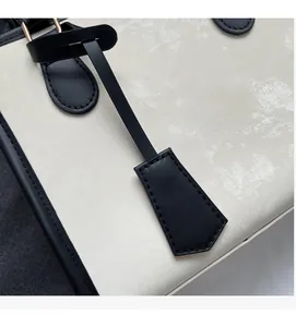 Detalle macro de bolso tote de cuero blanco con bordes negros de contraste elegante