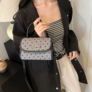 Chic grey mini handbag with black heart prints and a silver bow on a single shoulder strap