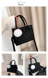Detail einer schwarzen Stepptasche aus Filz mit weißem Pelz-Pompon und abnehmbarem Gurt
