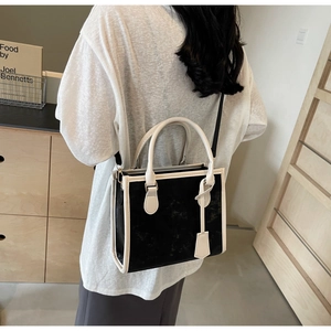 Vista de estilo de un bolso tote en contraste blanco y negro con asa y bandolera