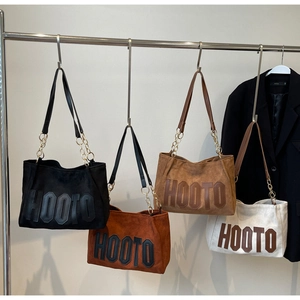 Detail showing the metal chain shoulder strap and suede texture of the HOOTO tote bag