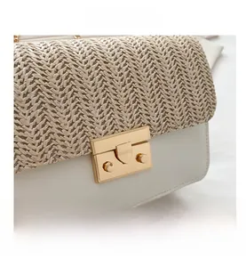 Close-up of straw woven and white leather patchwork handbag with gold metal lock