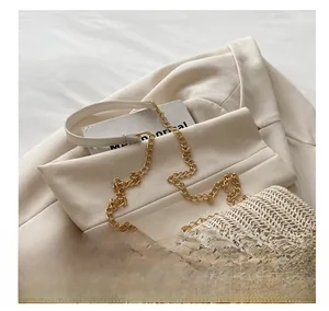 Detail of contrast stitch straw handbag with gold chain and leather patchwork strap