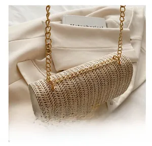 Detail of handwoven straw texture and golden chain strap on a stylish crossbody bag