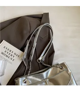 Detail of silver metallic tote bag with crinkled leather texture and chain strap
