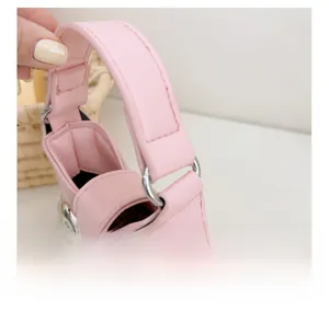 Detail showing the pink PU leather texture and silver butterfly buckle on a mini bag