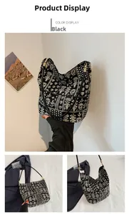 Détail du sac hobo à fleurs en toile noire avec une boucle en métal doré élégante