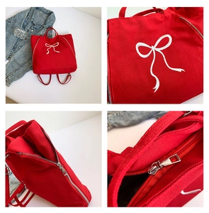 Détails du sac cabas en toile rouge avec broderie nœud, fermeture éclair et poches internes