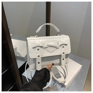 Detalle del bolso blanco de PU con lazo 3D, pespuntes de corazón y remaches plateados