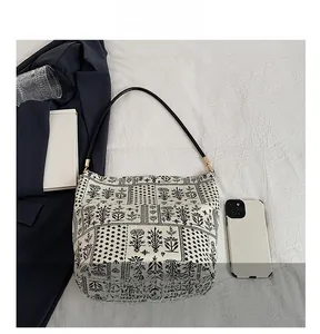 Détail du sac seau en toile avec motifs floraux rétro et attaches métalliques dorées