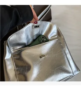 Detail of the internal slip pocket in a large silver tote bag showing storage capacity