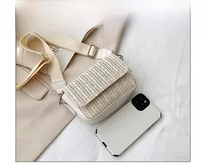 Detail of beige woven flap crossbody bag showing texture and adjustable canvas strap