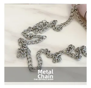 Detailed close-up of the silver hardware chain on a pink fashion crossbody bag