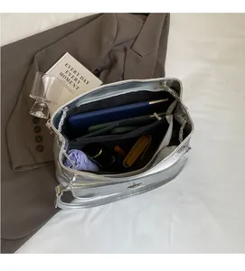 Detail view of large silver tote bag interior with multiple compartments and high capacity